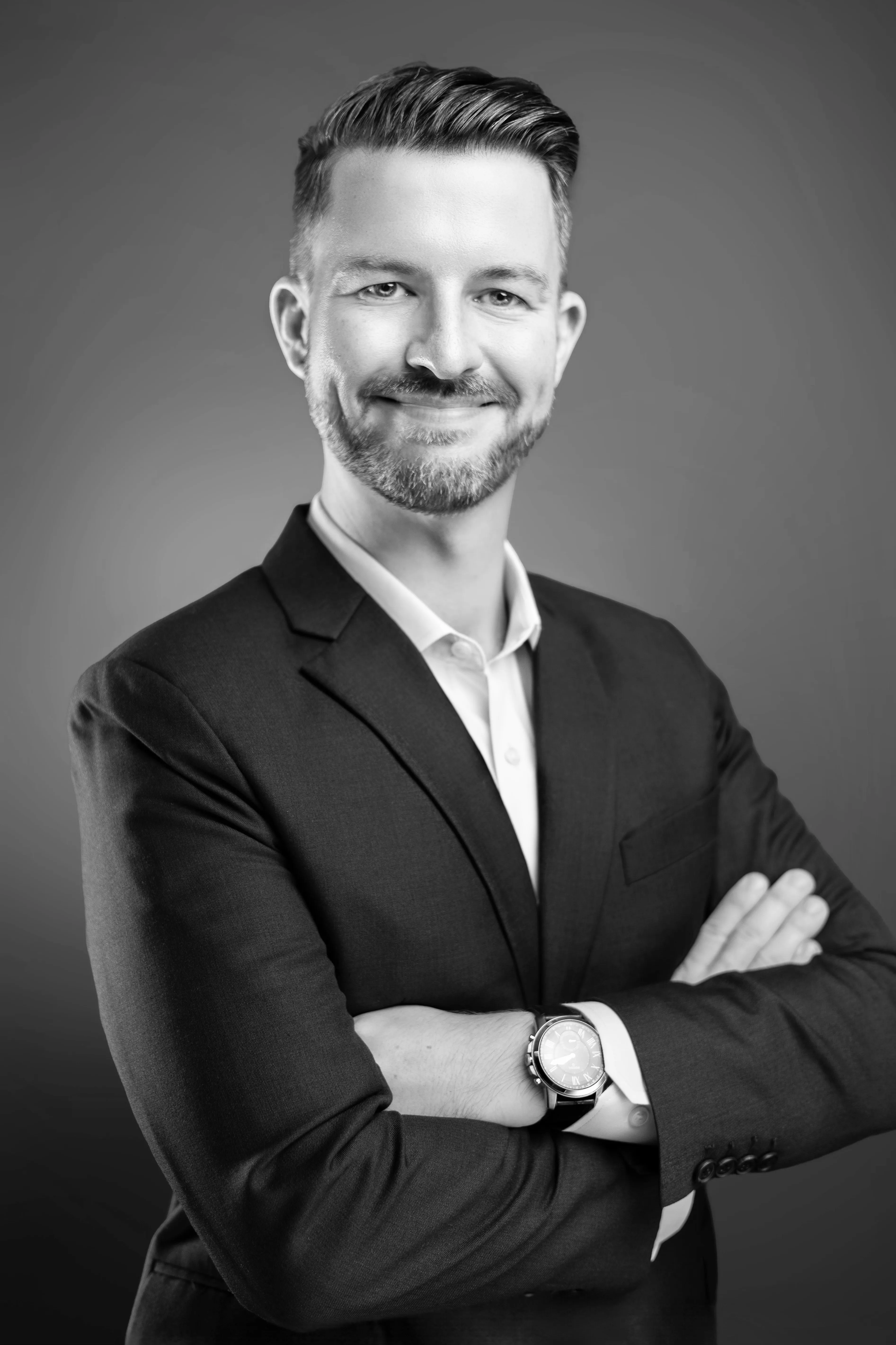 Chris Grabo, customer experience and customer success leader, in a dark suit with arms crossed.